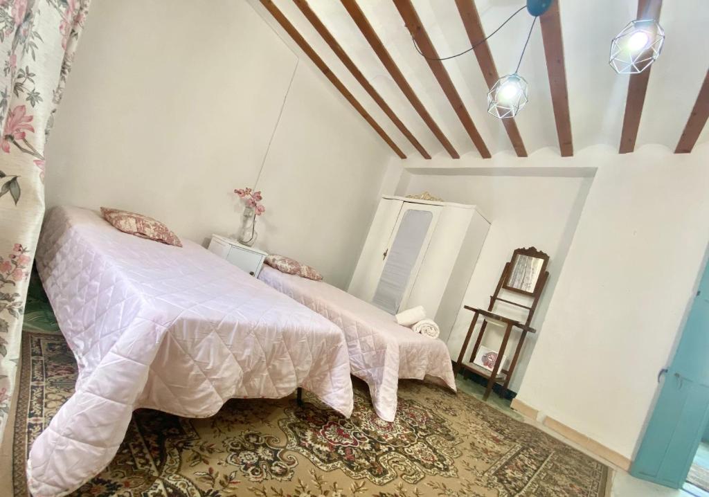 1 Schlafzimmer mit 2 Betten mit rosa Daunendecke in der Unterkunft Casa El Cerro in Villacarrillo