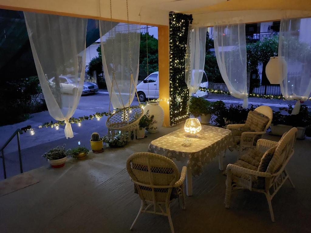 un patio con mesa, sillas y luces en Oranje Guesthouse en Itea