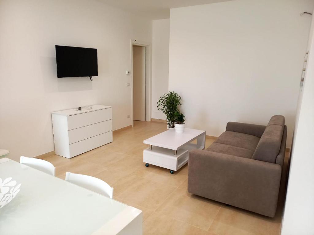 a living room with a couch and a tv at SALENTO AT HOME in Nardò