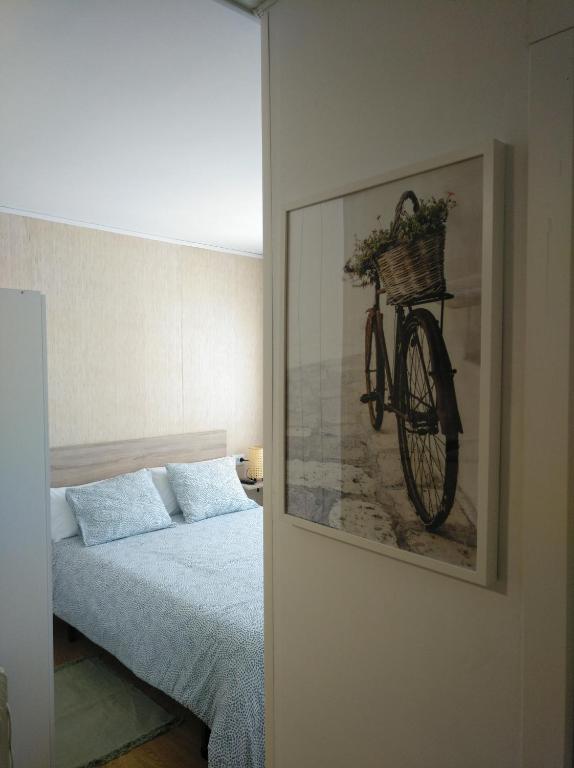 een slaapkamer met een fiets aan de muur bij Precioso Estudio in Sada