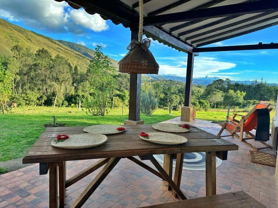 un tavolo in legno con piatti su un patio di Casita Icatá con vista a la montaña (A 5 minutos del pueblo) a Villa de Leyva