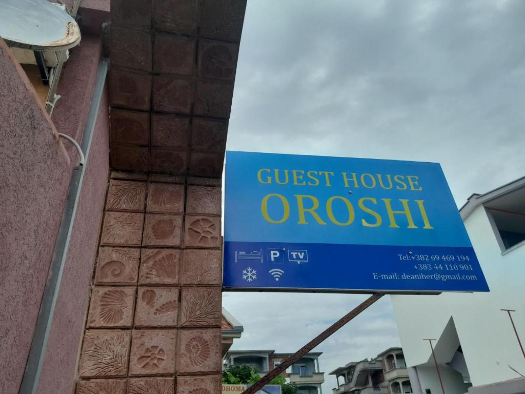 een bord voor een pension aan de zijkant van een gebouw bij Guest House Oroshi in Ulcinj