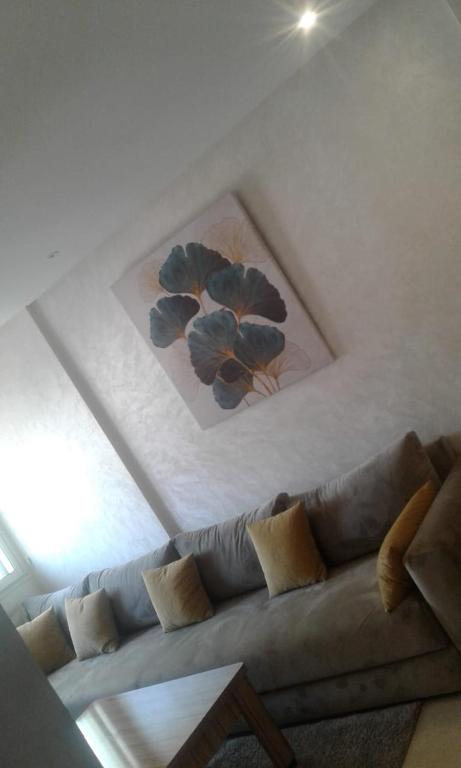 um sofá numa sala de estar com um quadro na parede em Immoagadir em Agadir