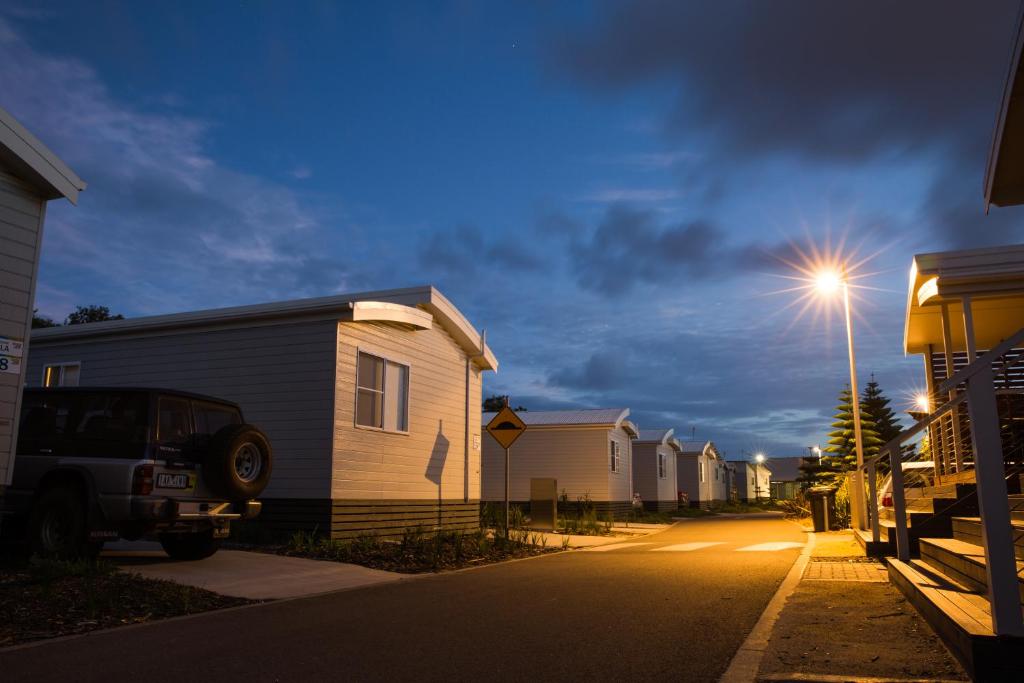 eine Reihe von Häusern auf einer Straße mit Straßenbeleuchtung in der Unterkunft NRMA Stockton Beach Holiday Park in Stockton