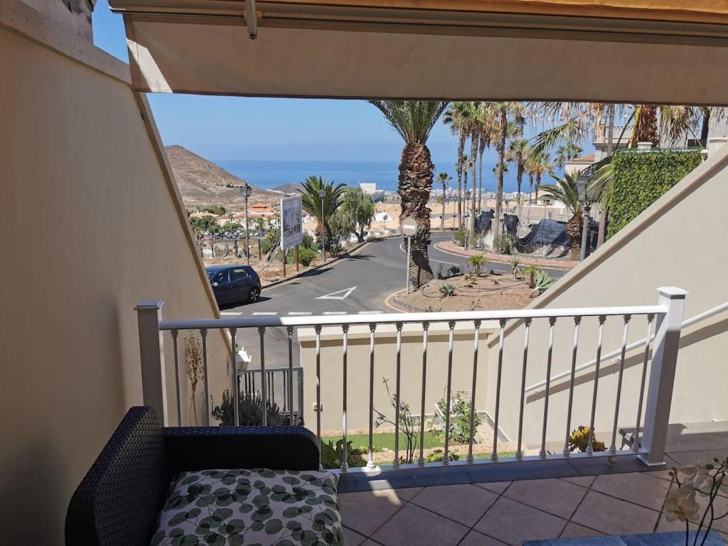 a balcony with a view of a street and palm trees at Relax and Enjoy in Tenerife Sud! in Chayofa
