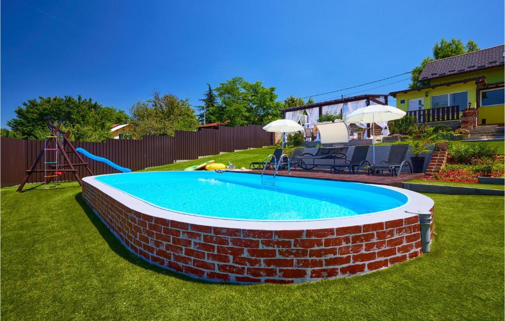 uma piscina num quintal com uma parede de tijolos em Gorgeous Home In Hrebinec With Jacuzzi em Hrebinec
