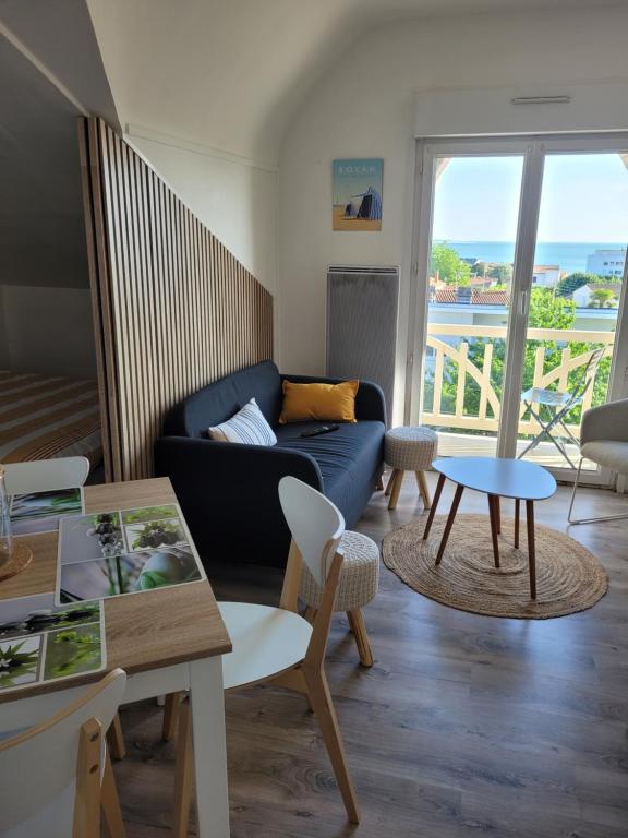 un salon avec un canapé et une table dans l'établissement Appt Pontaillac Vue Océan, à Royan