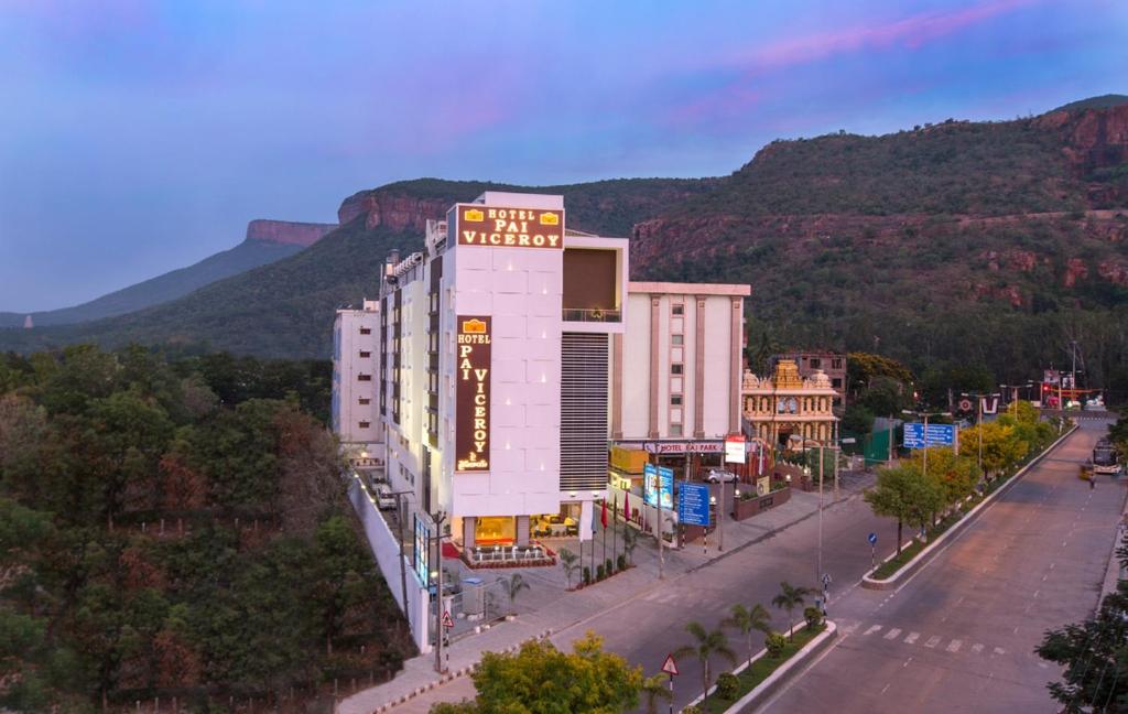 a building on a street with a mountain in the background at Pai Viceroy in Tirupati