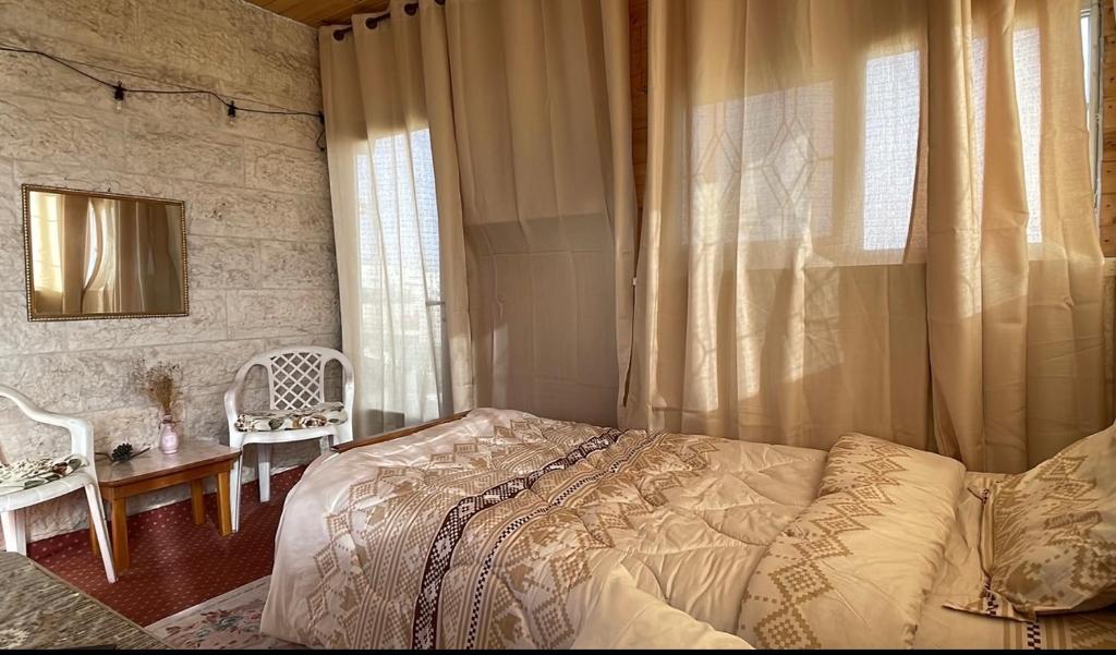 1 dormitorio con cama, mesa y ventana en Tamimi Home, en Hebron