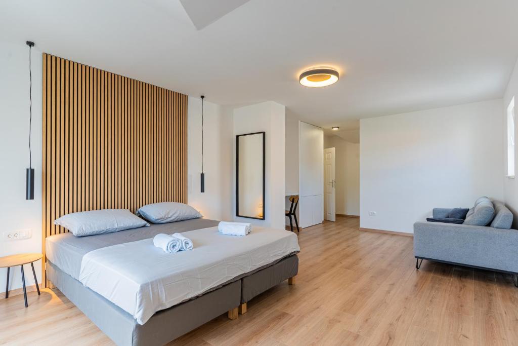 1 dormitorio con 1 cama grande y 1 sofá azul en Apartments & Rooms Klemenc en Cres