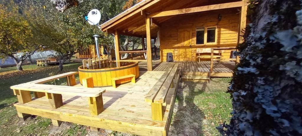 Cabaña con terraza de madera y banco en Karkú Lodge en Pucón