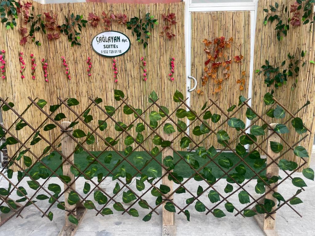 a fence with a bunch of plants on a wall at Çağlayan Suites Apart in Fethiye