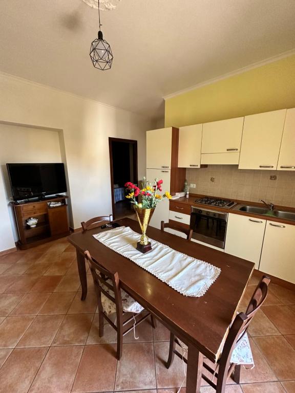 a kitchen with a wooden table with a vase of flowers on it at Casa Fiorella in Fiano Romano