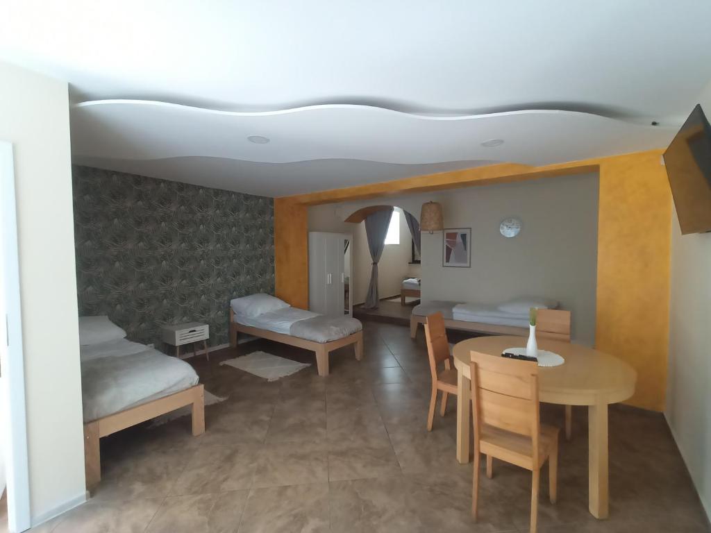 a room with two beds and a table and chairs at Apartament 592 in Boguszów-Gorce