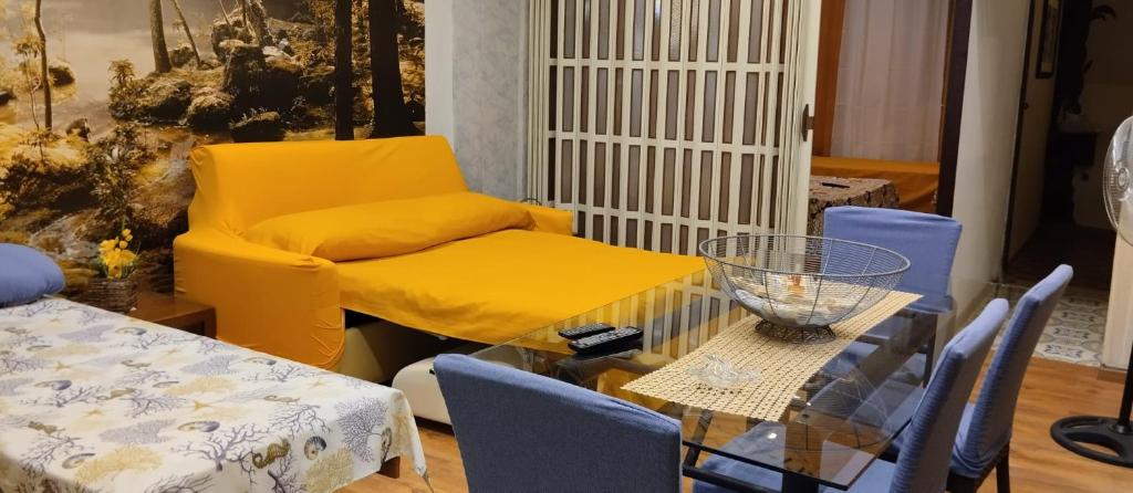 un salon avec une chaise jaune et une table dans l'établissement Dal corso al mare, à Spadafora