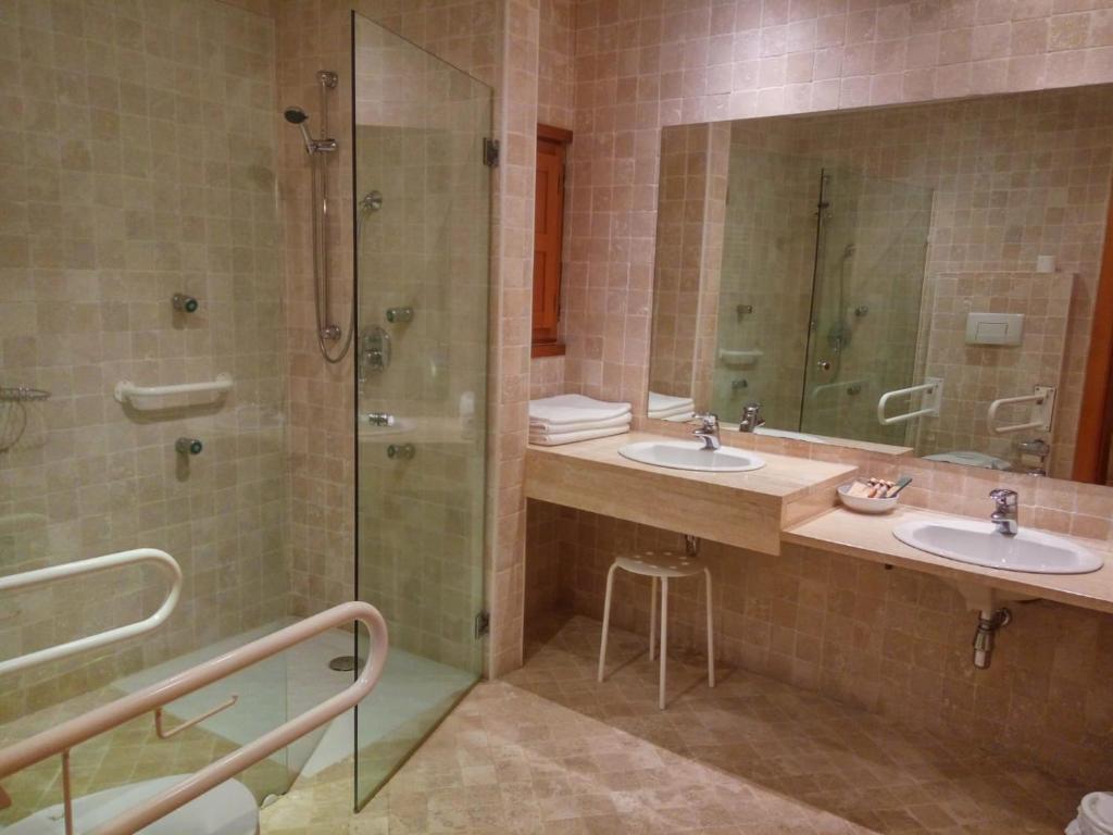 uma casa de banho com 2 lavatórios e um chuveiro em El Milano Real em Hoyos del Espino