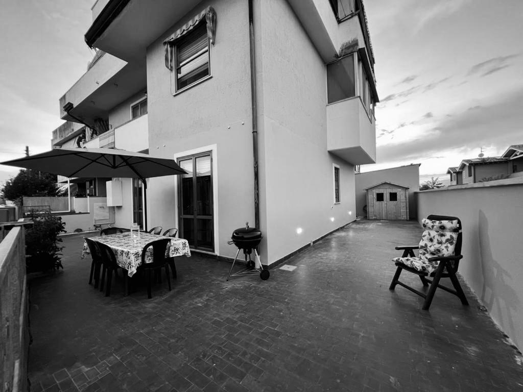 維亞雷焦的住宿－Appartamento Sunflower，庭院配有桌椅和遮阳伞。