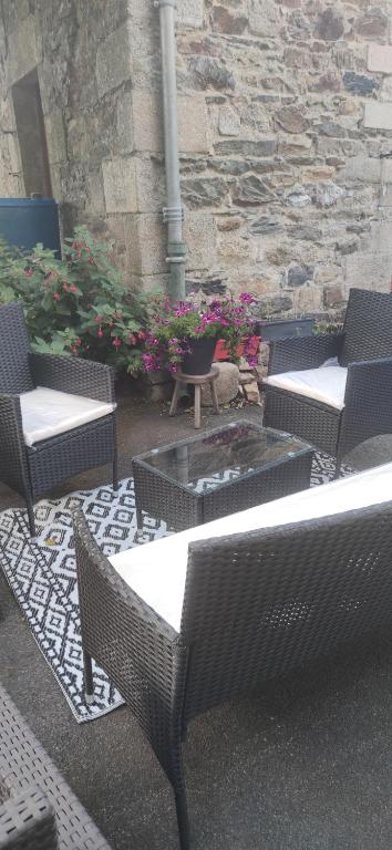 a patio with wicker chairs and a fire pit at Relais De La Tour in Callac