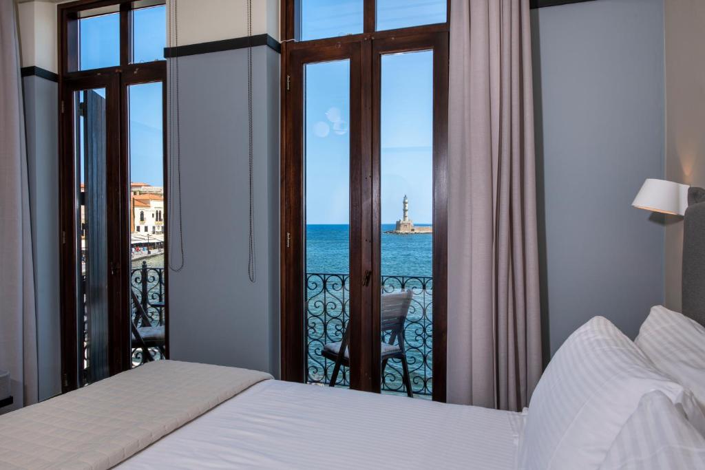 a bedroom with a bed and a view of the ocean at Mosaic Venetian Harbour Suites in Chania Town