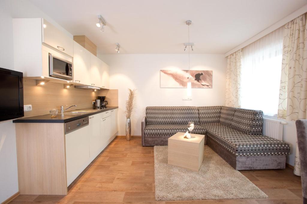 cocina y sala de estar con sofá y mesa en Haus Kristall, en Serfaus
