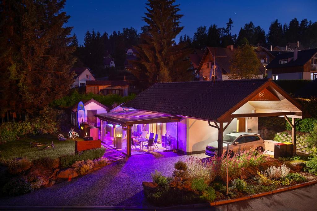 ein nachts beleuchtetes Haus mit lila Lichtern in der Unterkunft Rekreační domek Kobylnice Lipno in Lipno nad Vltavou