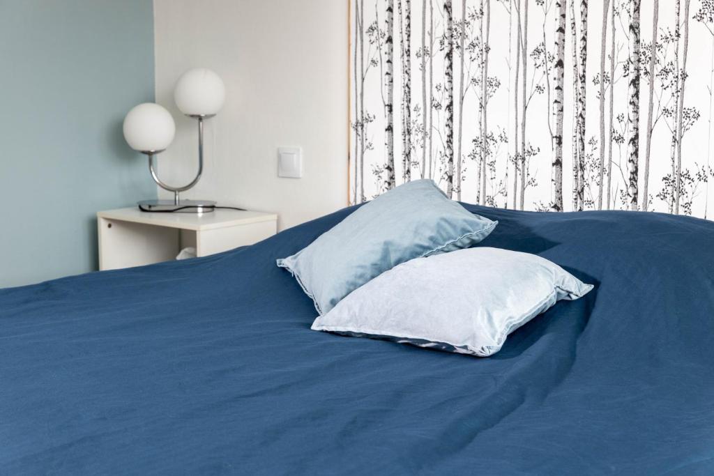 - un lit bleu avec 2 oreillers au-dessus dans l'établissement Blue Vibes, à Saint-Avold