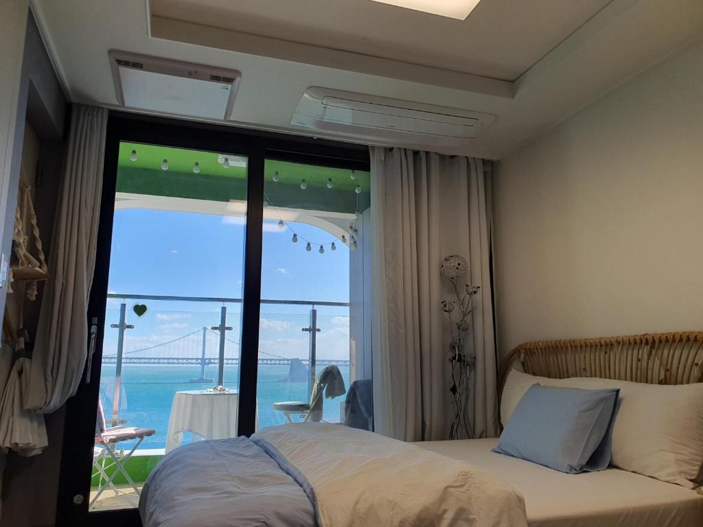 a bedroom with a bed and a view of a bridge at Gwangalli Ocean View One Studio in Busan