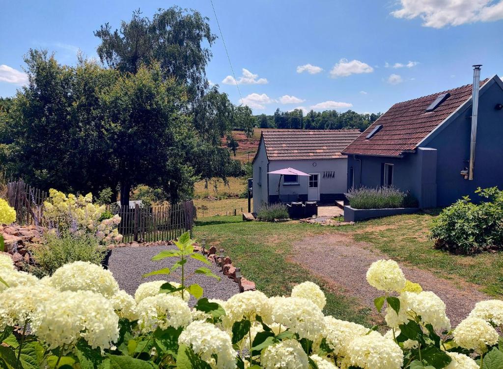 a garden with white flowers in front of two houses at Maison du Grand Moulin in Saint-Aubin-en-Charollais