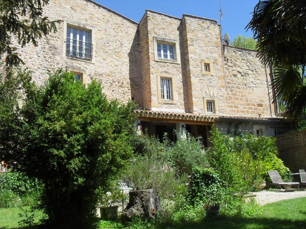 an old stone building with a bench in a garden at Maison d'Hotes Le Val d'Aleth in Alet-les-Bains