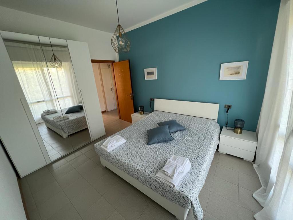 - une chambre bleue avec un lit et un miroir dans l'établissement Terrazza sul lago (CIR 017085-LNI-00027), à Iseo
