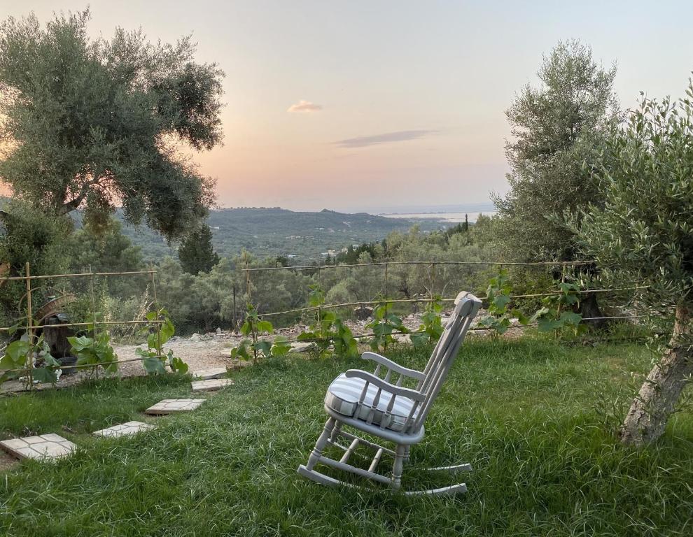 a chair sitting in the grass in a field at Cozy 2-bdrm-house with garden and view, Katouna Home III in Katouna