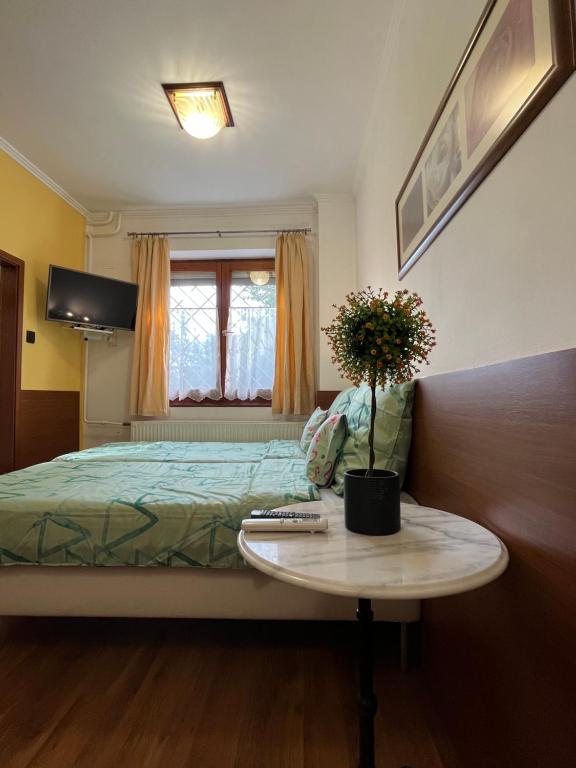 a bedroom with a bed and a table with a vase of flowers at Tang house 唐舍 in Budapest