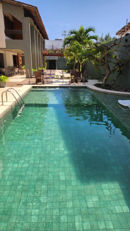 a swimming pool with green tiles in a resort at Pousada Costa Marina in Fortaleza