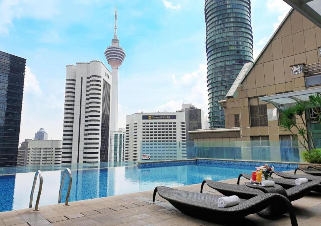una piscina con tumbonas y vistas al perfil urbano en KLCC by SWITZHOME, en Kuala Lumpur