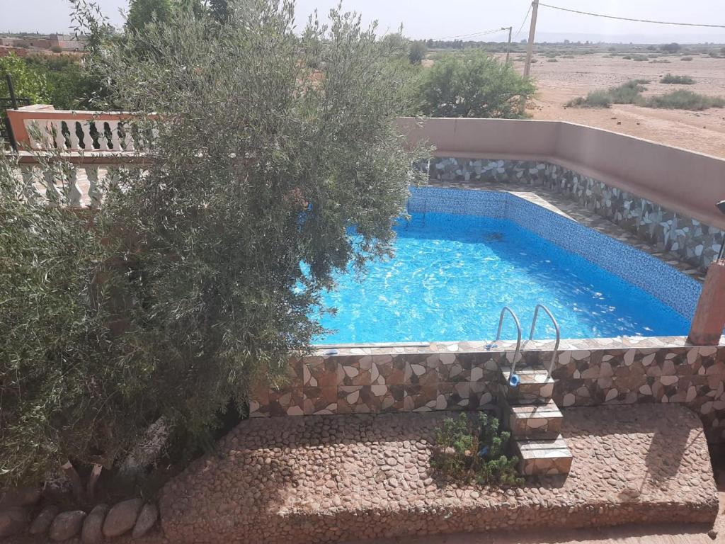 een zwembad in het midden van een tuin bij Magnifique ferme avec piscine in Marrakesh