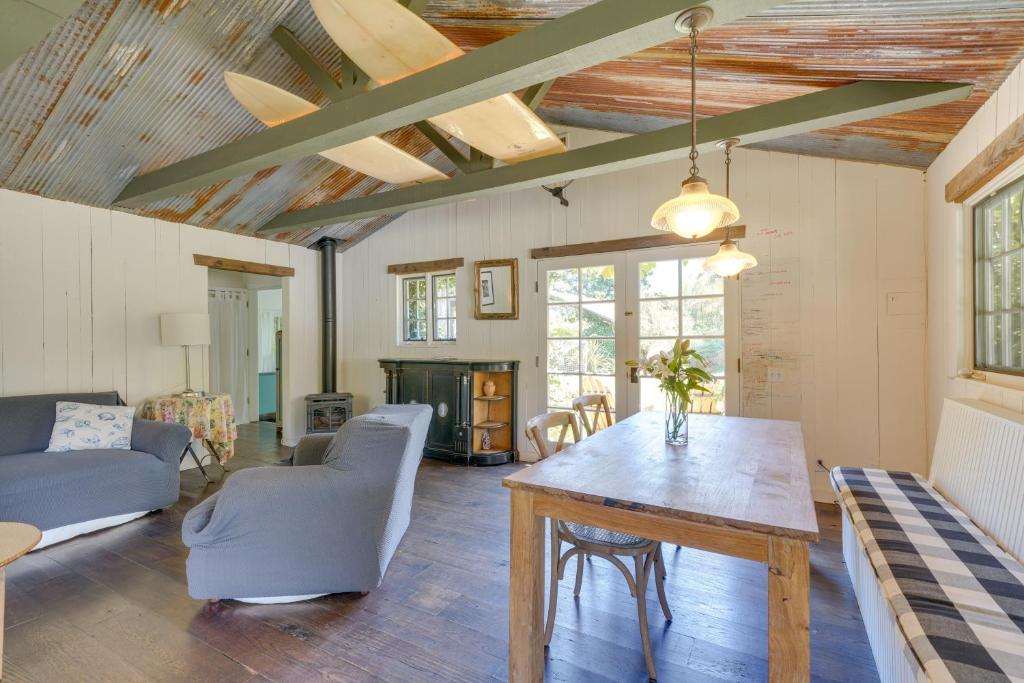 sala de estar con mesa de madera y sillas en Farmhouse-Chic Carpinteria Cottage with Pool Access, en Carpinteria