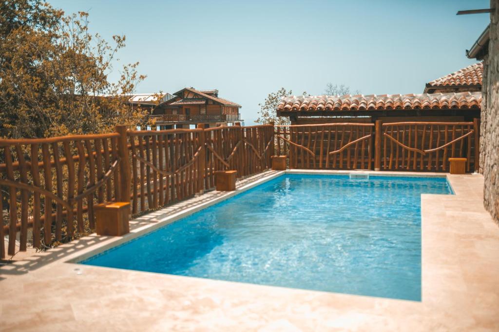 a swimming pool in front of a wooden fence at Resort & Villas Carević in Budva