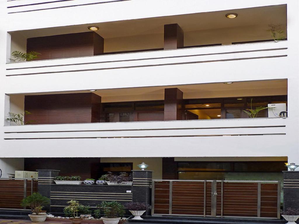 a white building with potted plants in front of it at Red Maple Bed & Breakfast in New Delhi