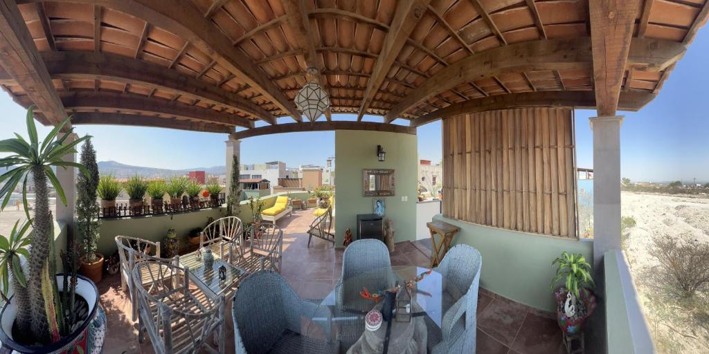 patio z krzesłami i stołami na balkonie w obiekcie casa la vida es buena w mieście San Miguel de Allende