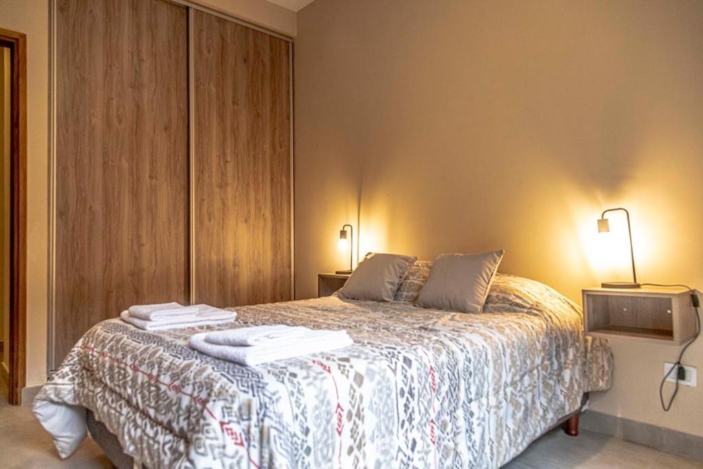 una camera da letto con un letto e due asciugamani di Departamento Moreno Park a Mendoza