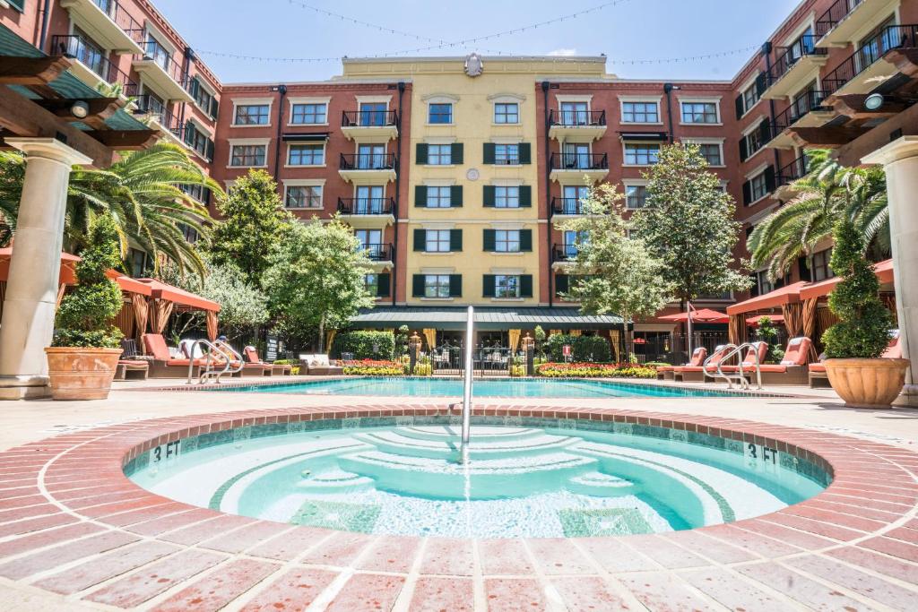 a pool with a fountain in front of a building at Hotel Granduca Houston in Houston