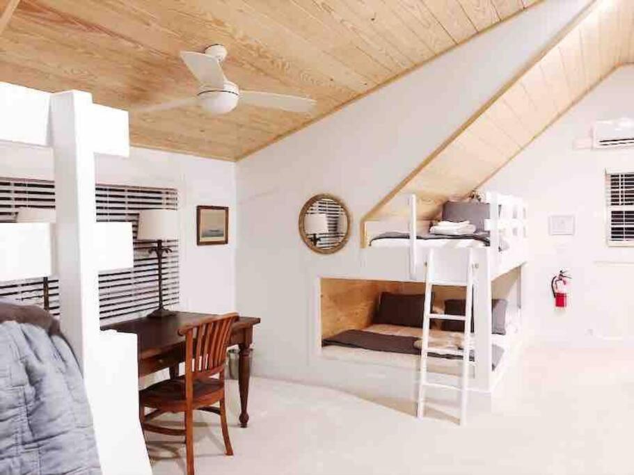 1 dormitorio con escritorio y litera en Liz Lane Cottage- entire guesthouse en Charleston