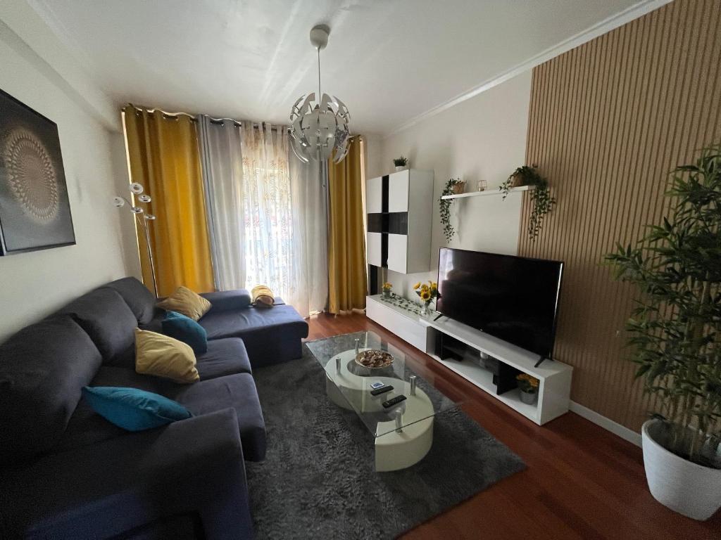 a living room with a couch and a tv at N3 Apartment in Amadora