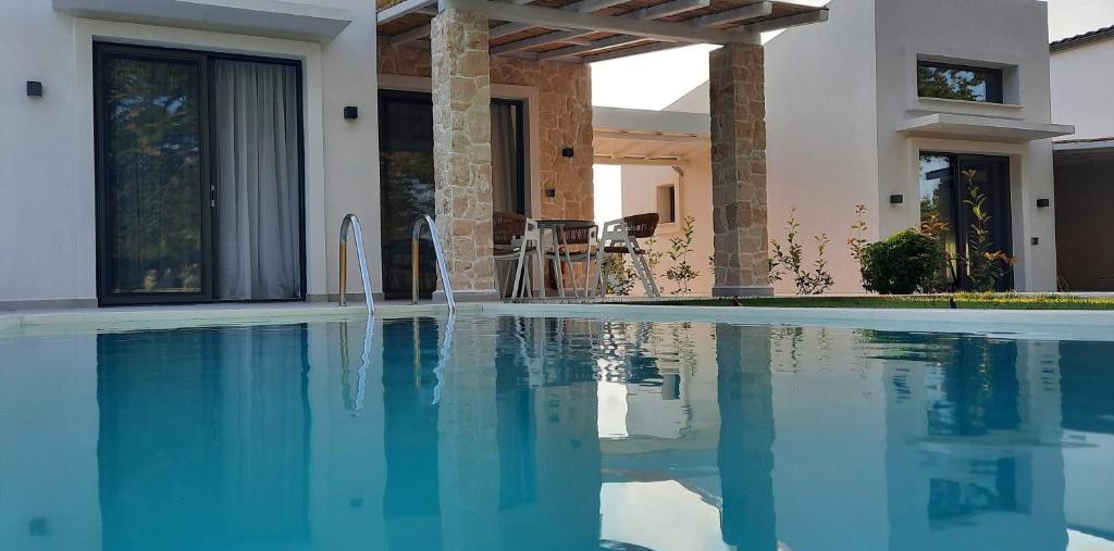 a swimming pool in front of a house at Astrum Luxury Suites in Vourvourou