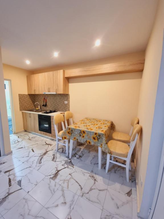 a kitchen with a table and chairs on a marble floor at Rental House Tale in Tale