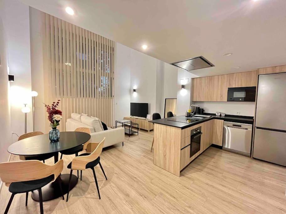 uma cozinha e sala de estar com mesa e cadeiras em WeRentVLC - Espectacular Loft Duplex 1 hab em Valência
