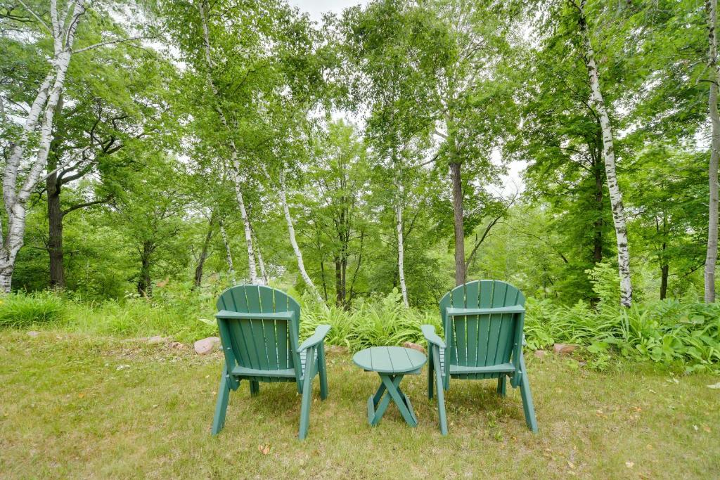 zwei grüne Stühle und ein Tisch im Gras in der Unterkunft Riverfront Bliss in Rice Lake Deck, Grill and Hike! in Mikana