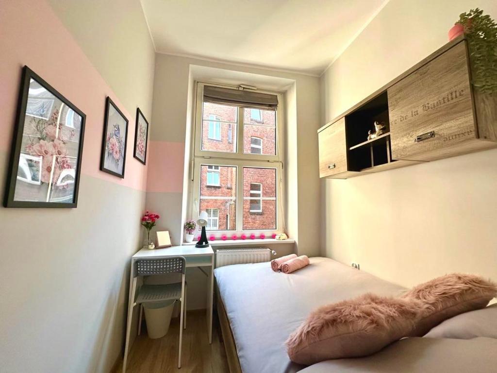 Habitación pequeña con 2 camas y ventana en MMRent Sparrow Room, en Gdansk