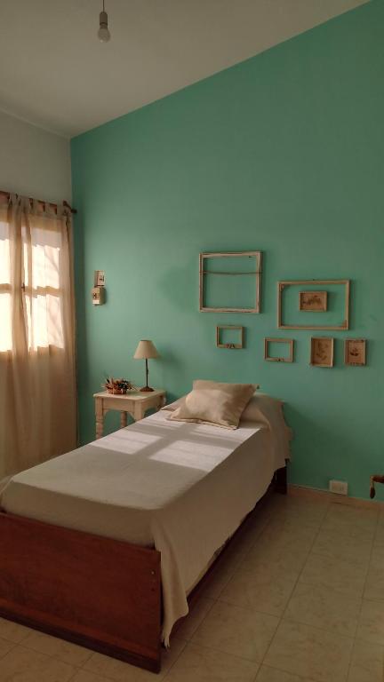 a bedroom with a large bed with a blue wall at Casa Isabella in Villa Dolores