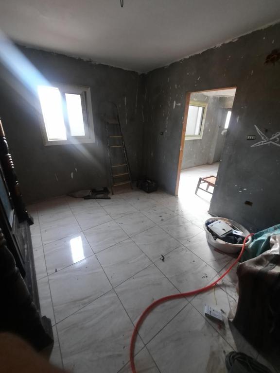 een lege kamer met een tegelvloer en 2 ramen bij المرج الشرقيه ش احمد ابو طالب in Caïro
